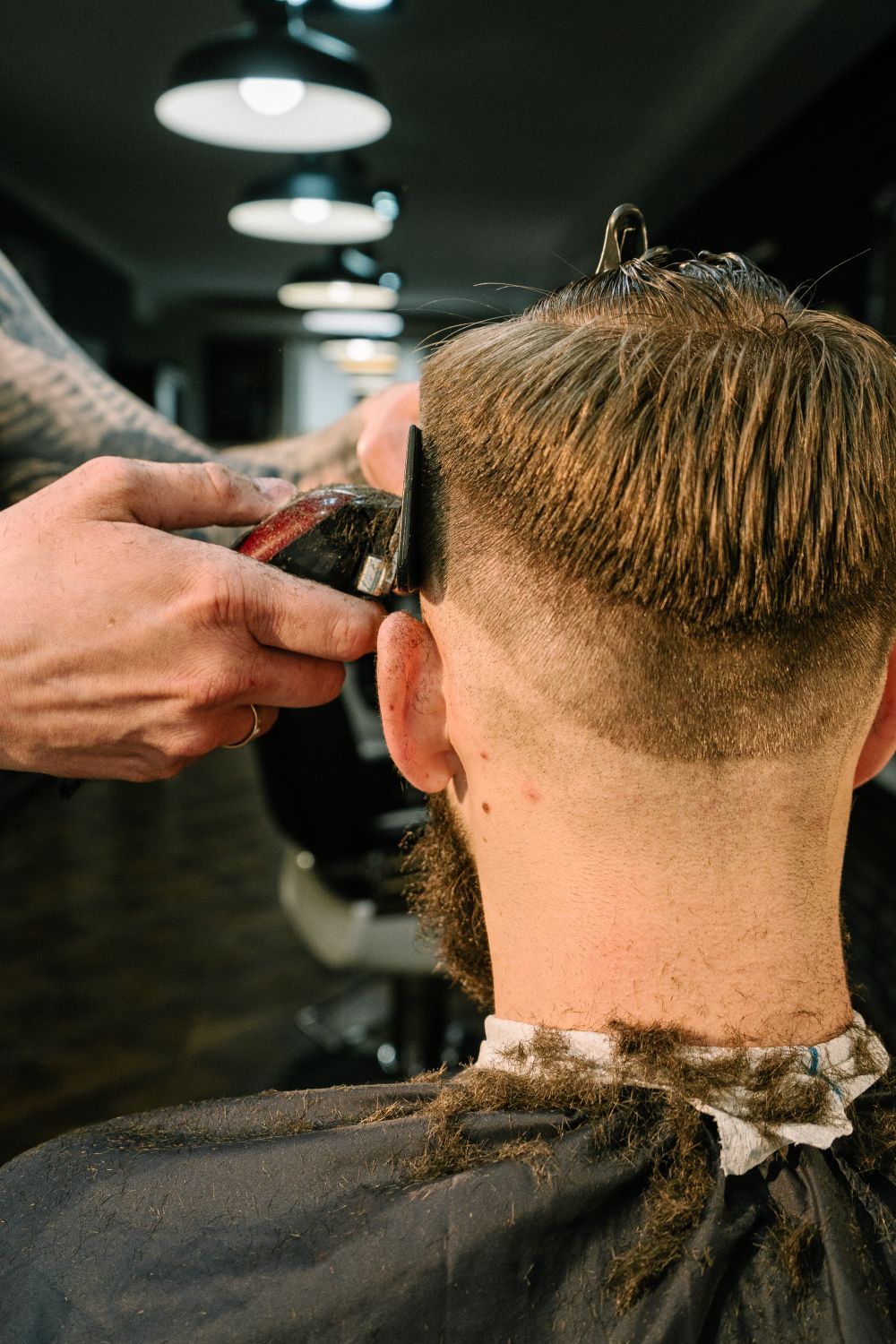 A barber giving a customer a fade haircut